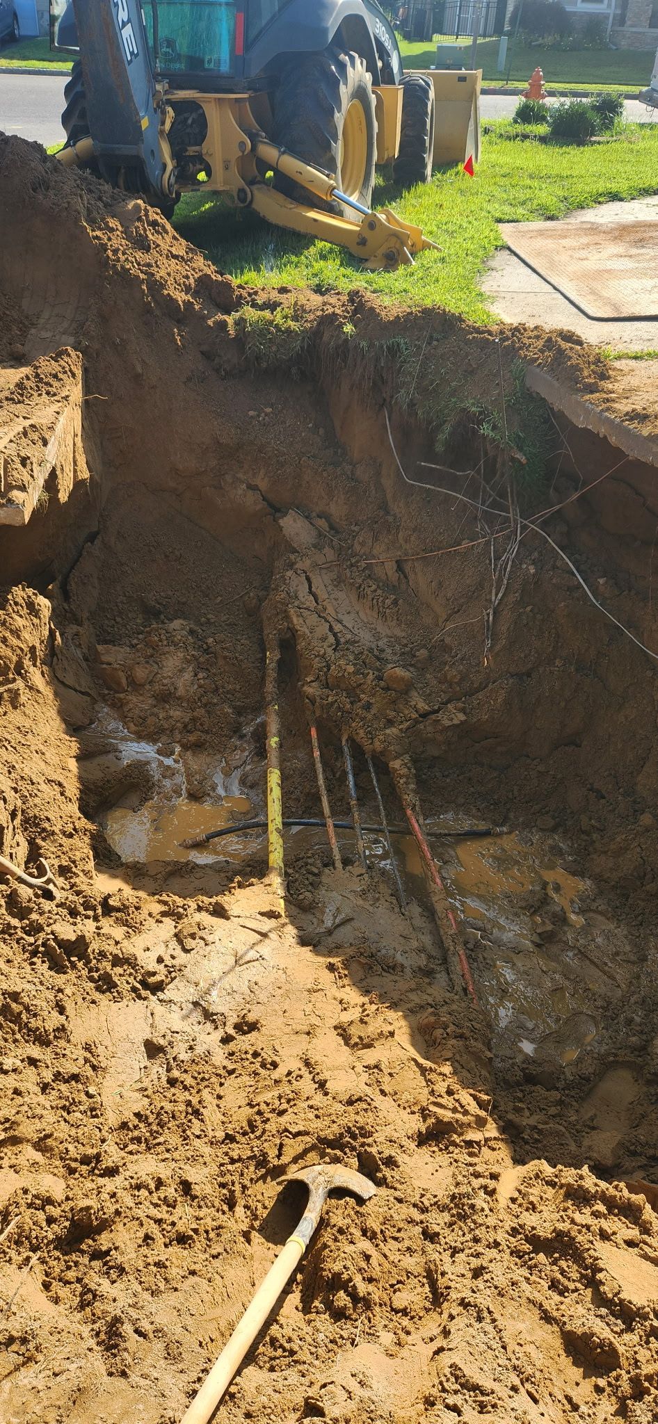 Two pipes are being installed in a trench in the dirt.