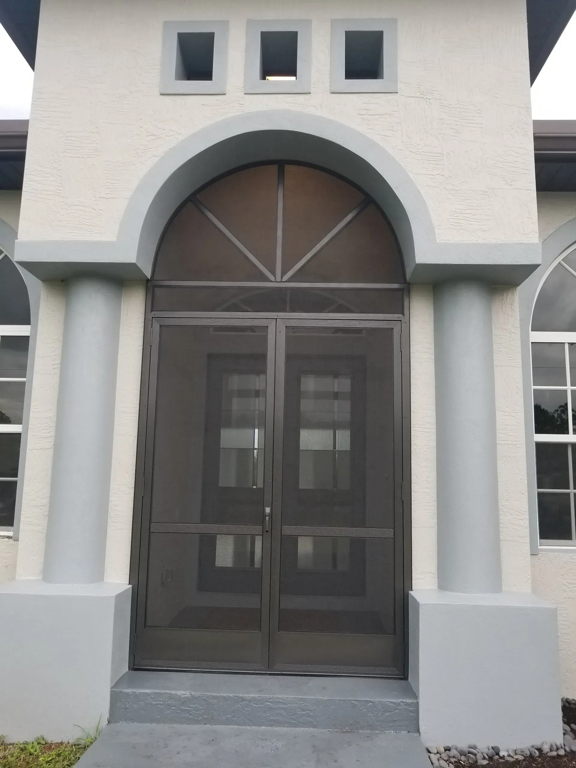 The front door of a house with a screen door.