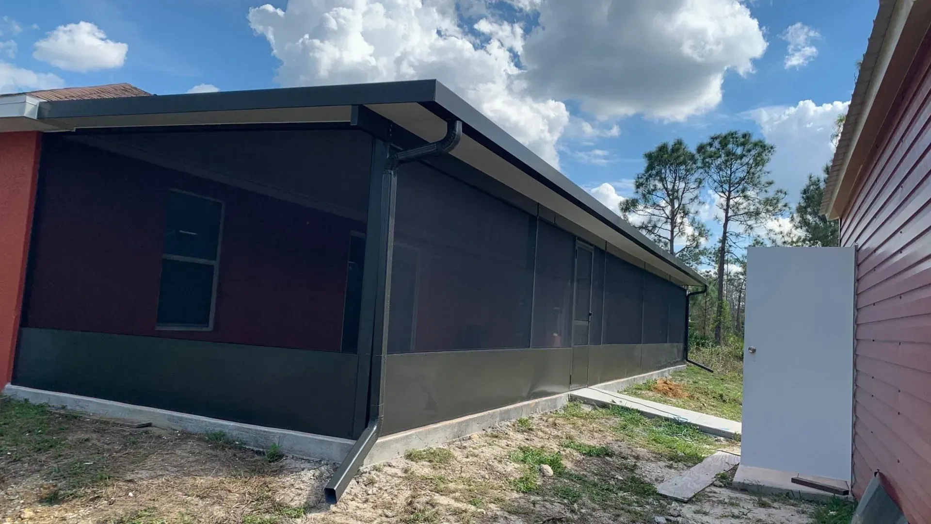 A house with a screened in porch and a white door.