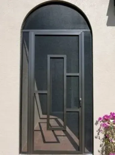 A black door with an arched window on a white wall.
