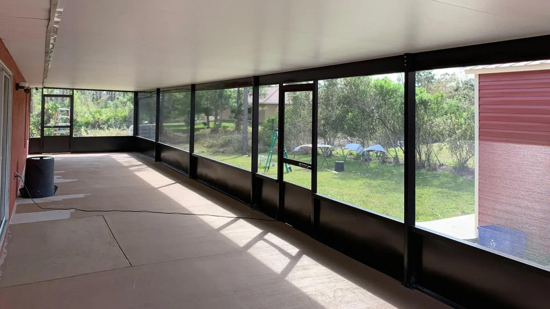 A screened in porch with a lot of windows.