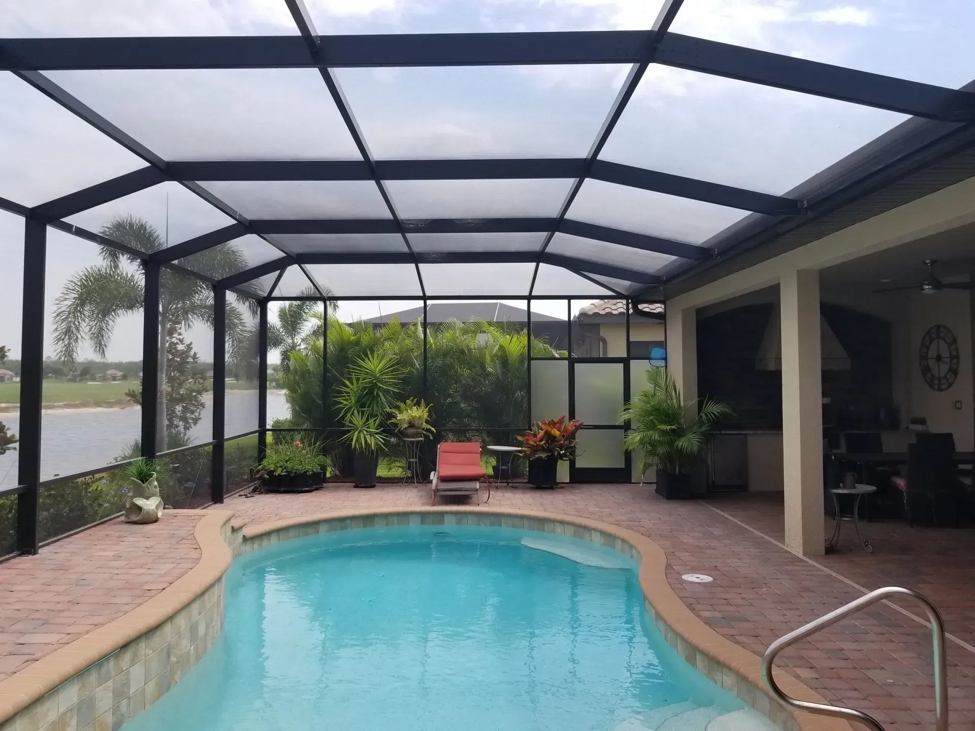 A large swimming pool with a screened in area surrounding it.