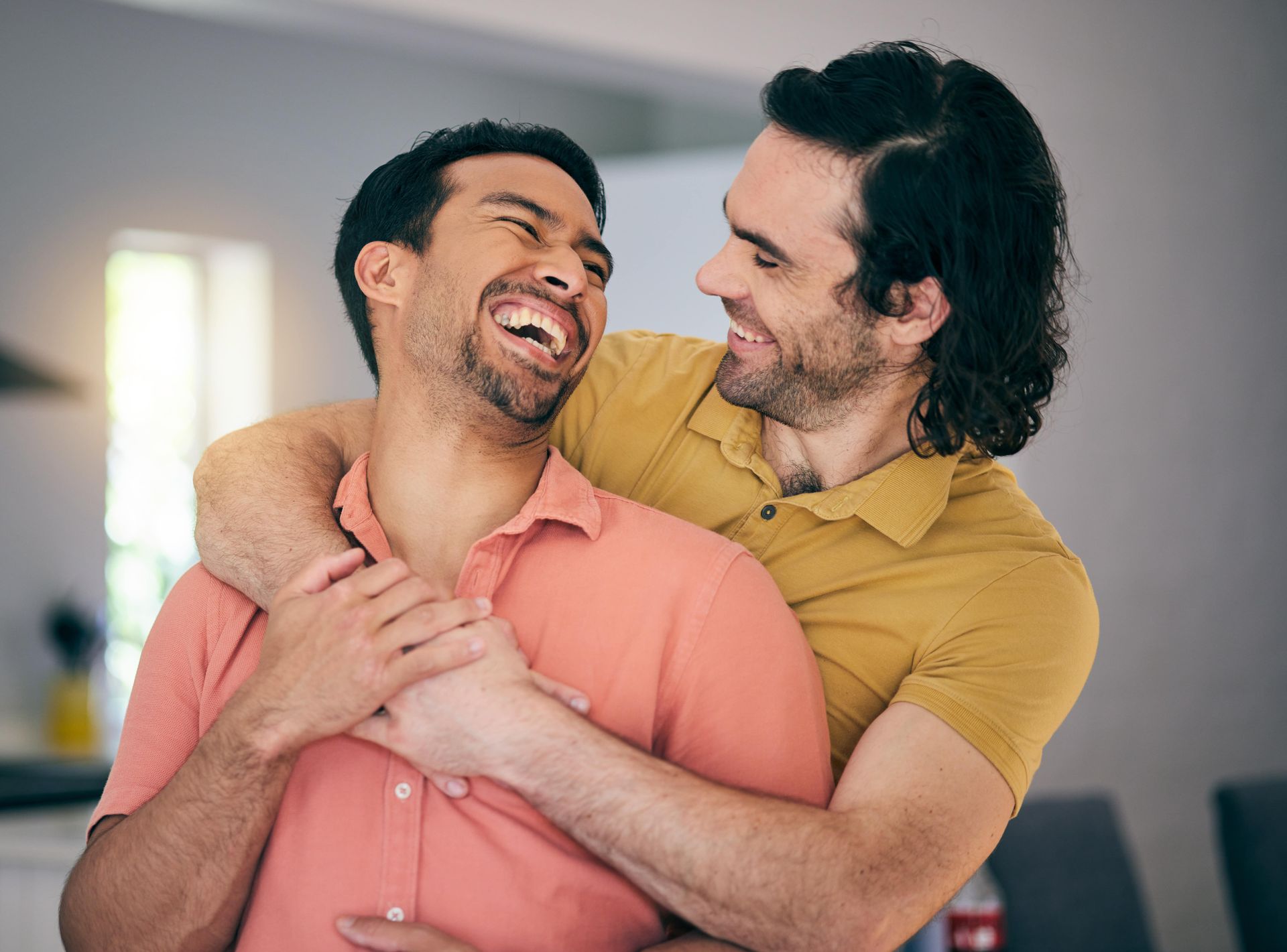 A man is kissing another man on the cheek.