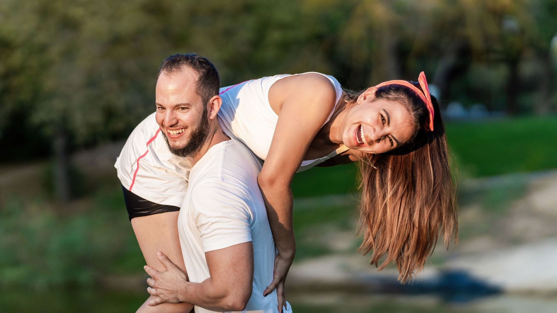 A rainbow flag is waving in the wind against a blue sky.