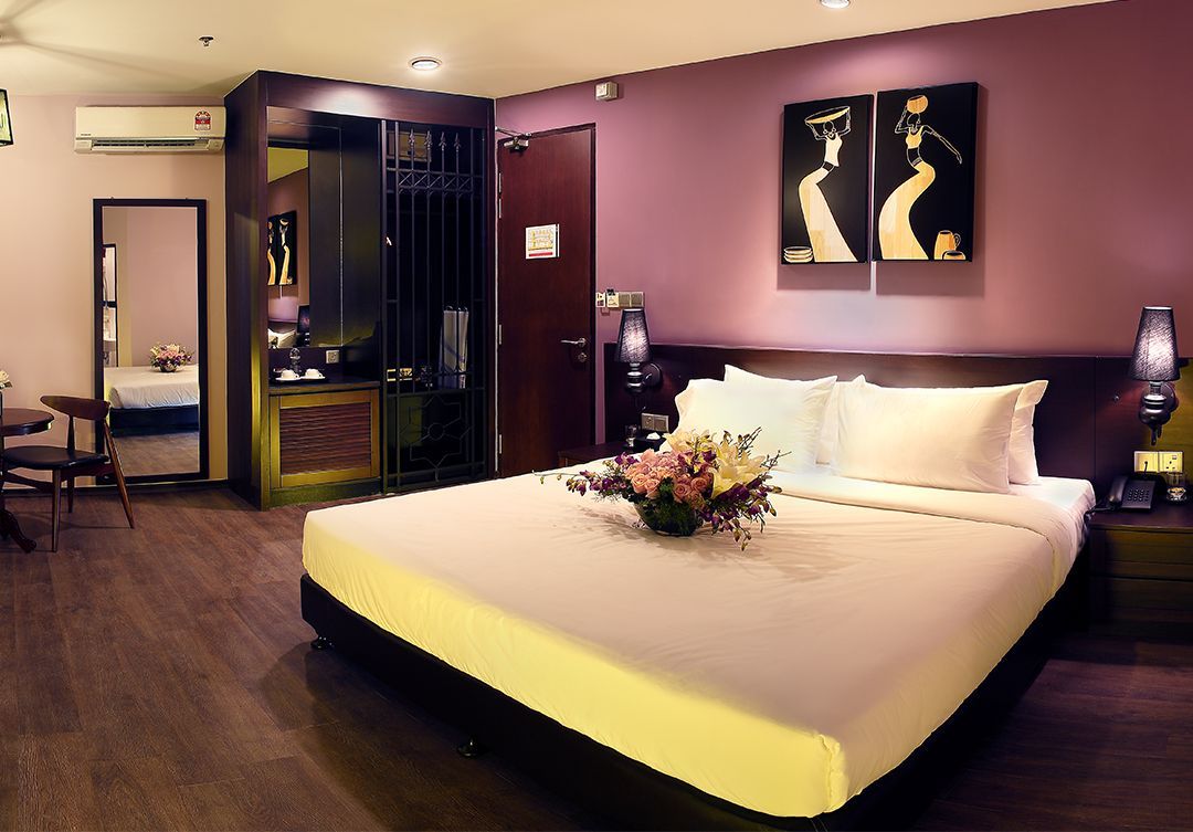 A hotel room with a large bed and purple walls