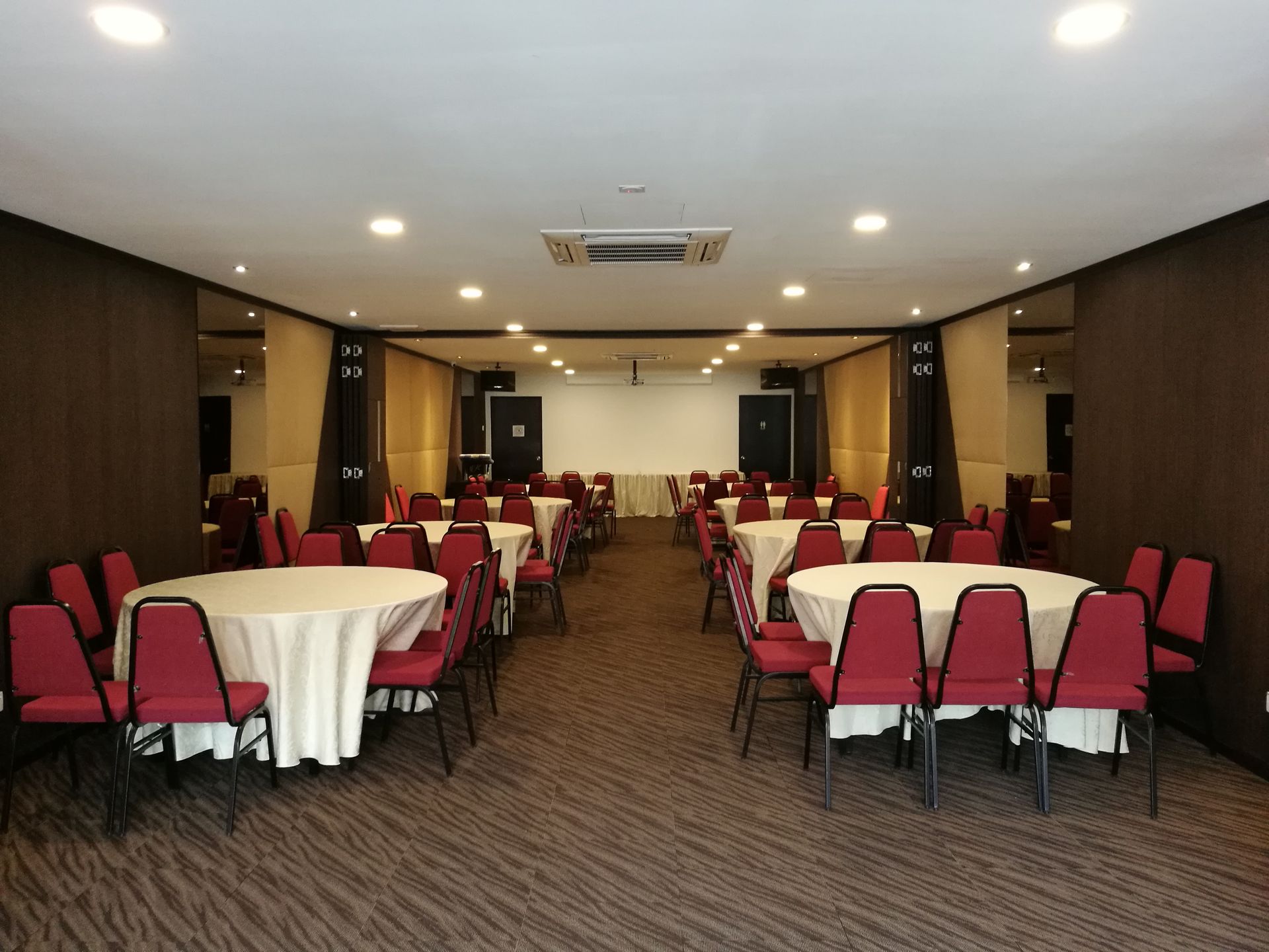 A large room with tables and chairs set up for a banquet.