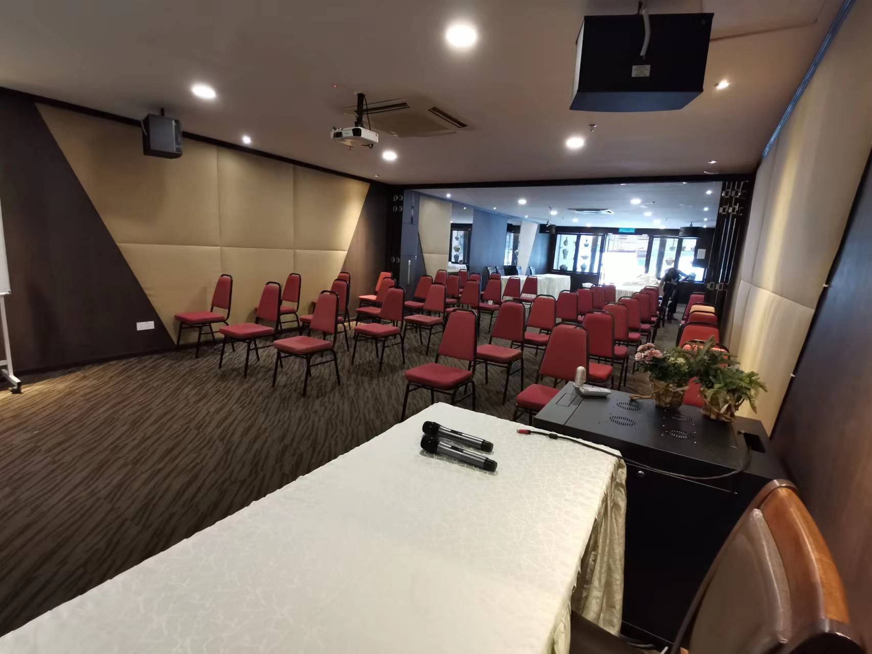 A conference room with tables and chairs and a projector.