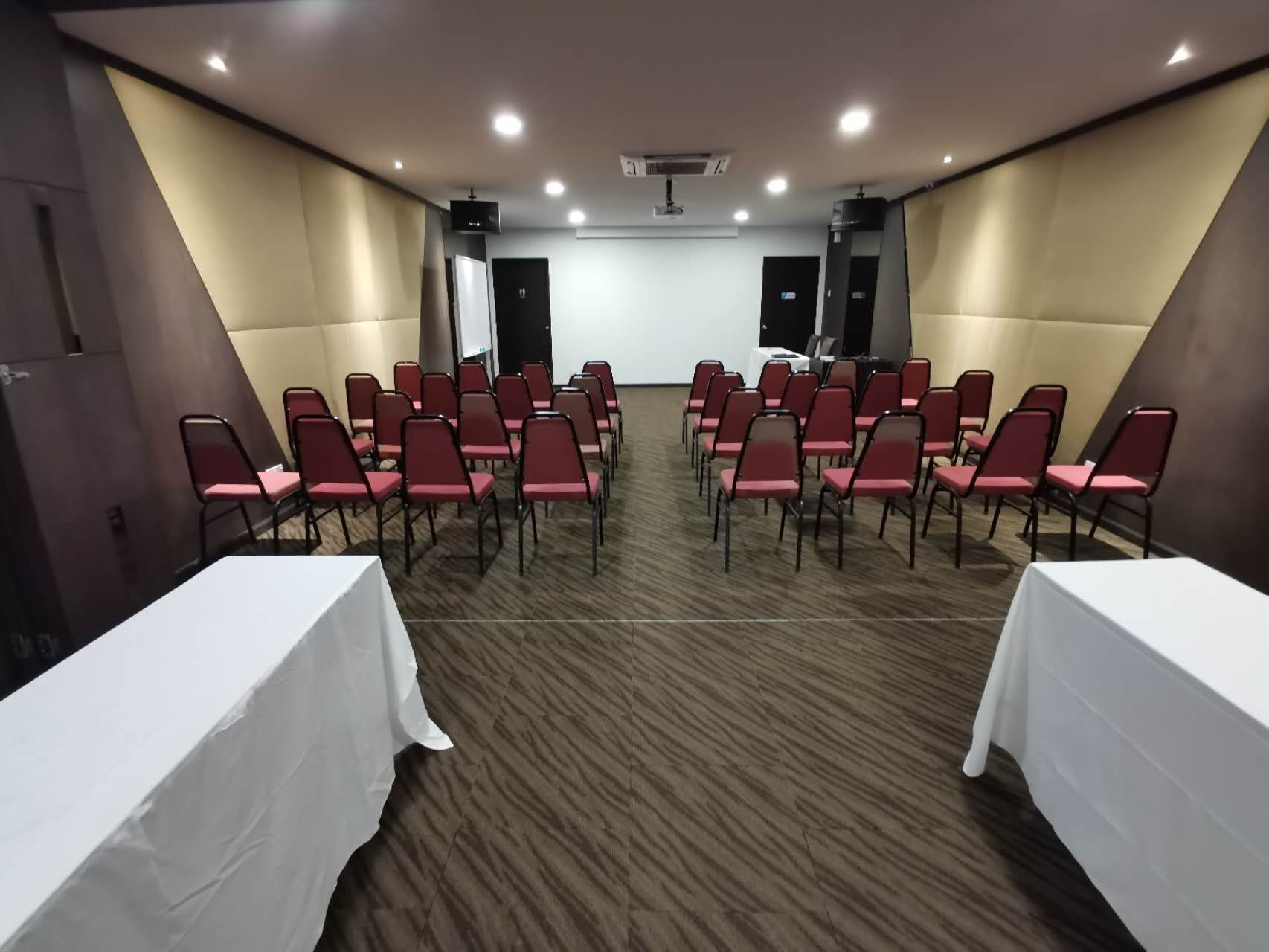 A conference room with red chairs and white tables