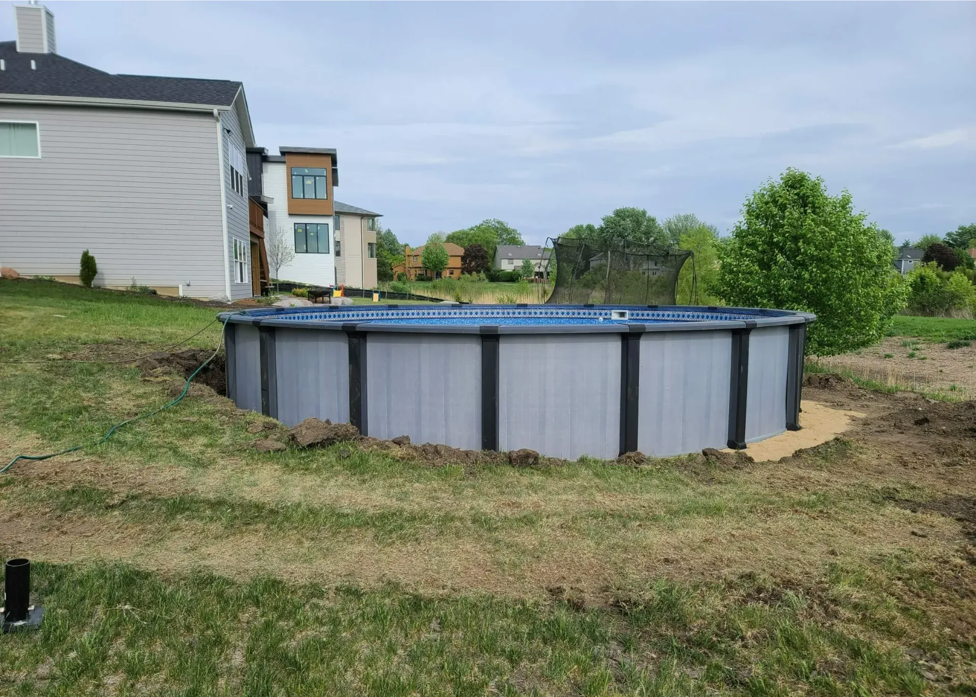 Inground rectangle fiberglass pool with corner sun shelf.