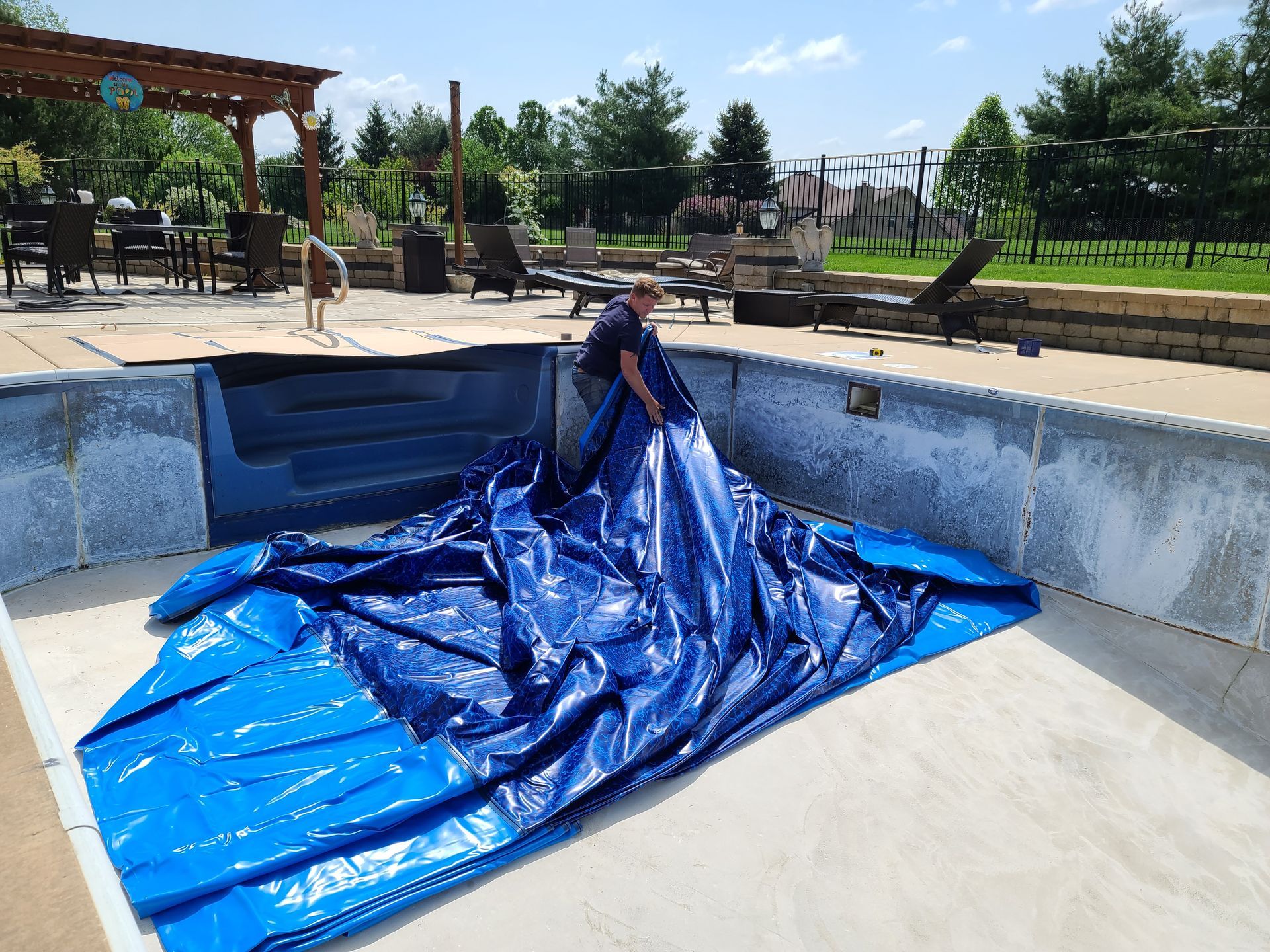 An empty swimming pool with a blue liner in it.