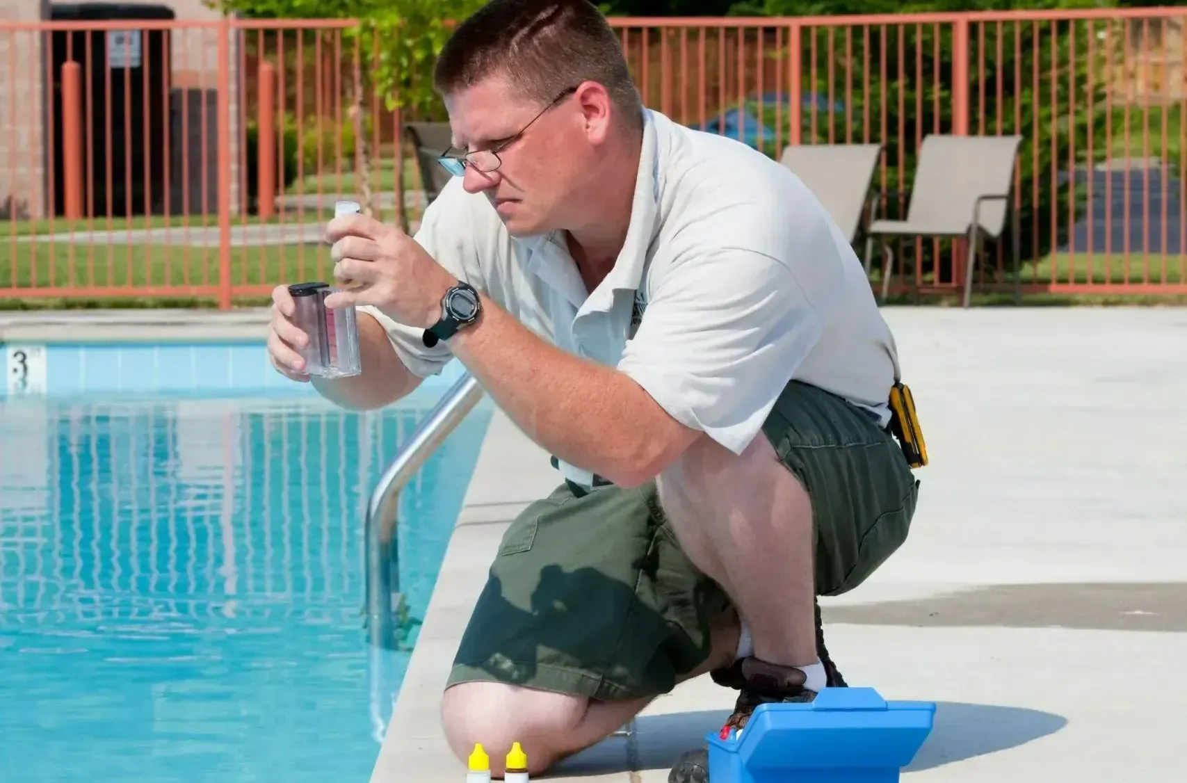 a swimming pool contractor testing the water chemistry of an inground pool