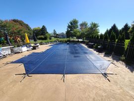a heavy duty safety cover being installed on a pool