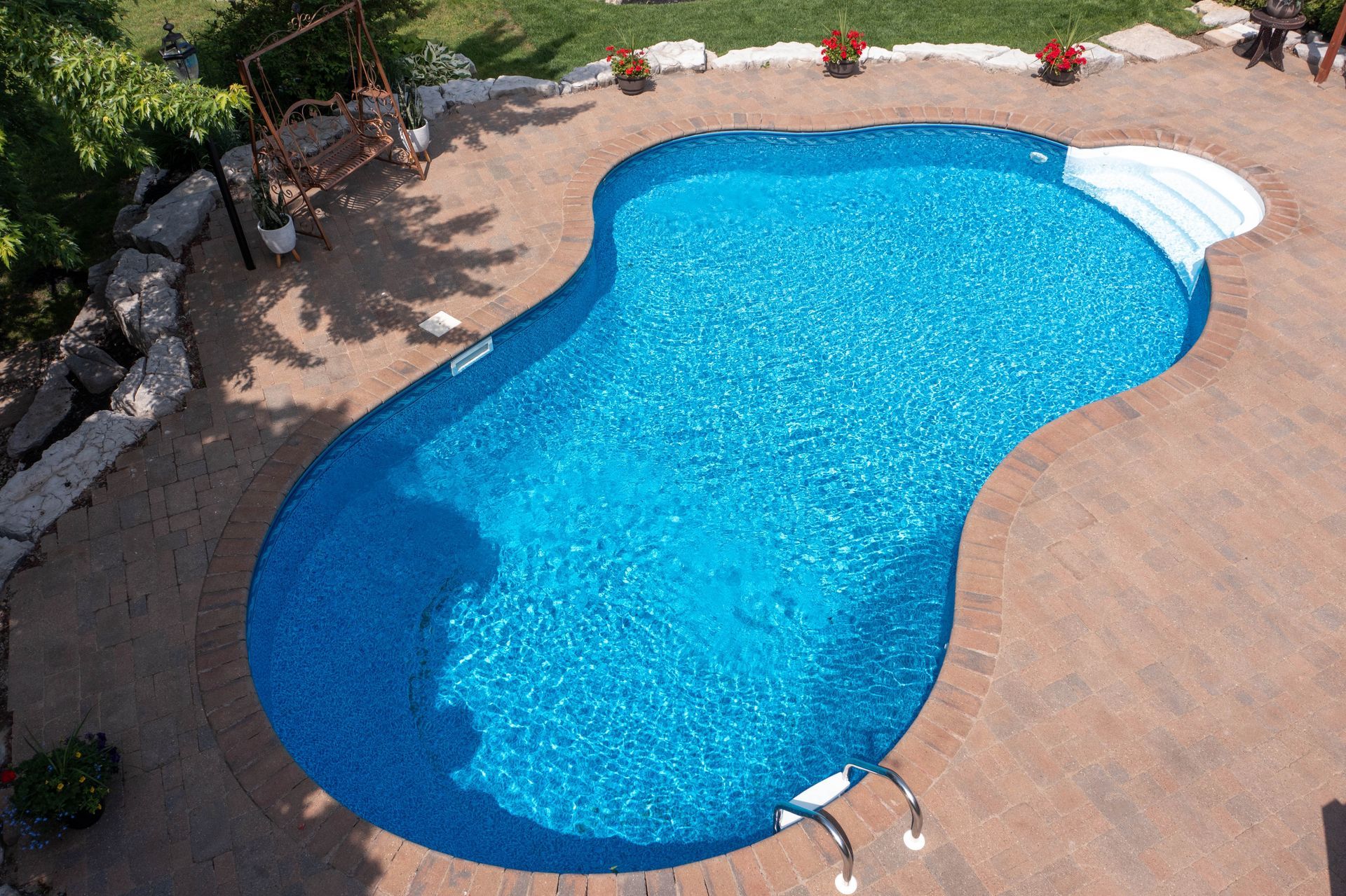 an aerial view of a large swimming pool in a backyard