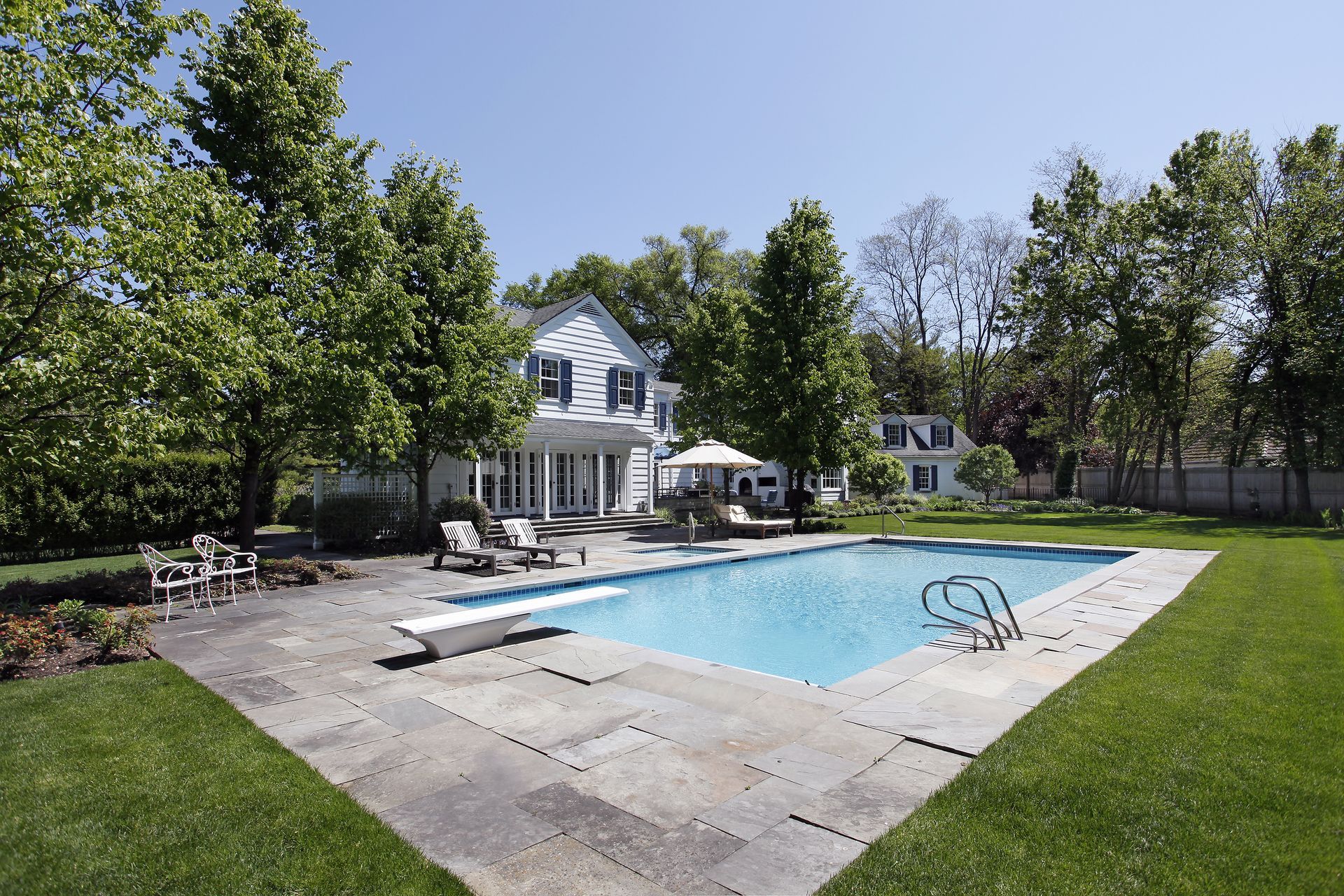 a large fiberglass swimming pool in the backyard of a house