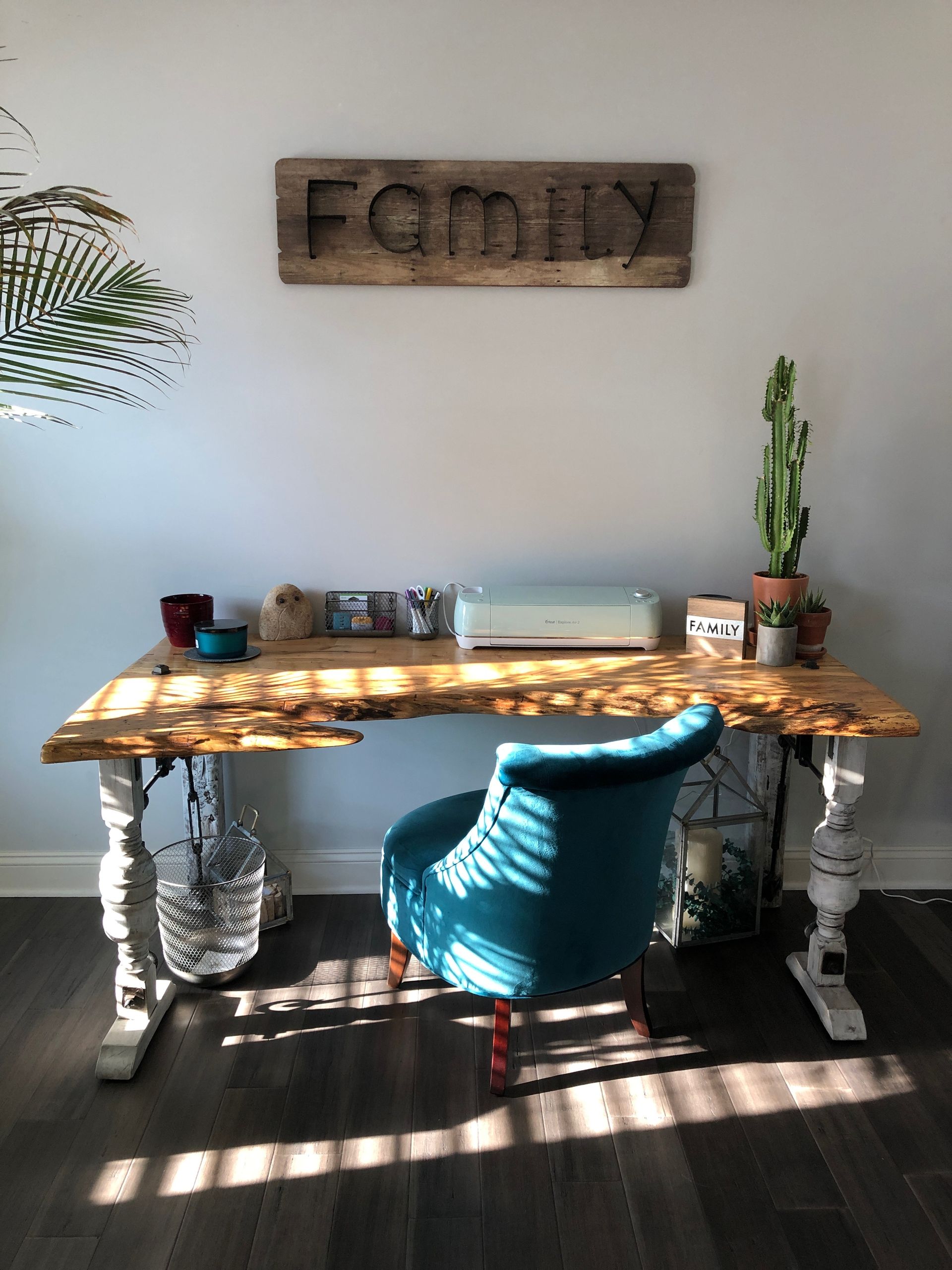 A desk with a chair and a sign that says family on the wall above it.