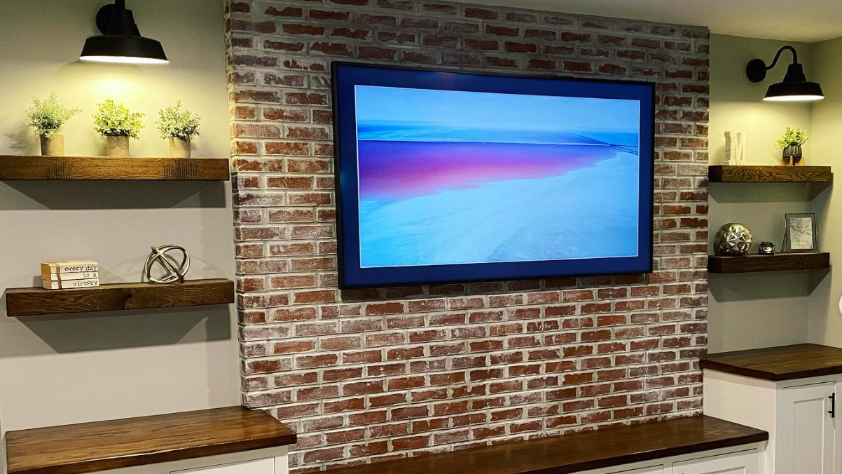 a flat screen tv is mounted on a brick wall .