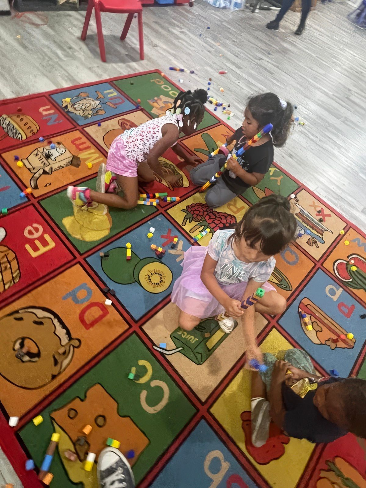 Children playing with colorful blocks on a rug.