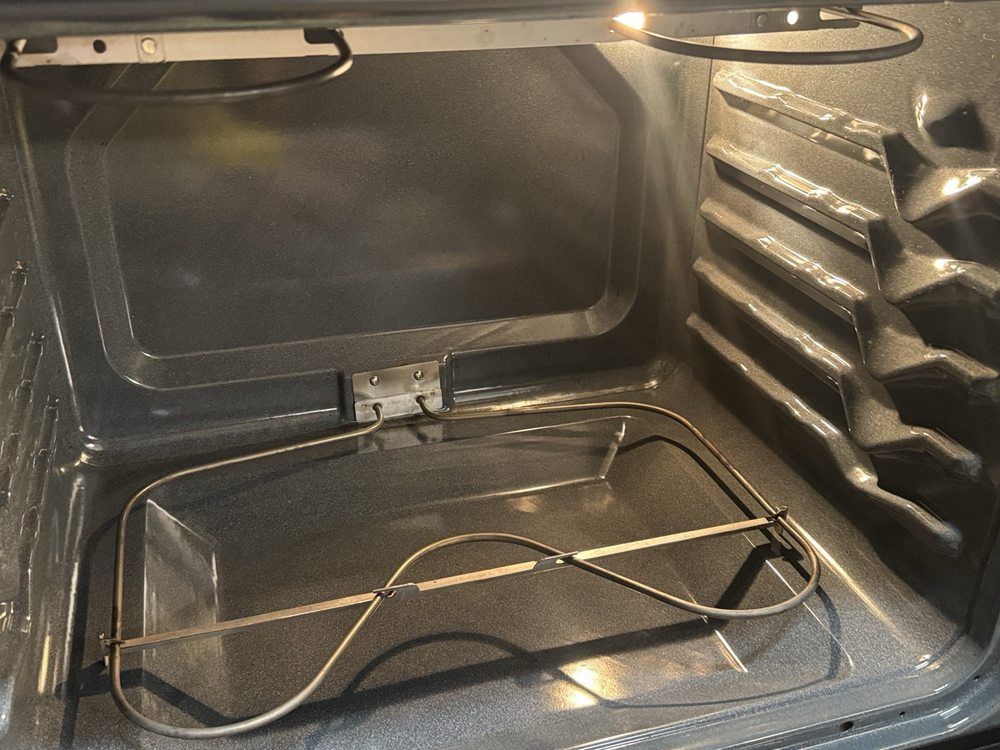 Inside of an oven, empty, with a heating element at the bottom.