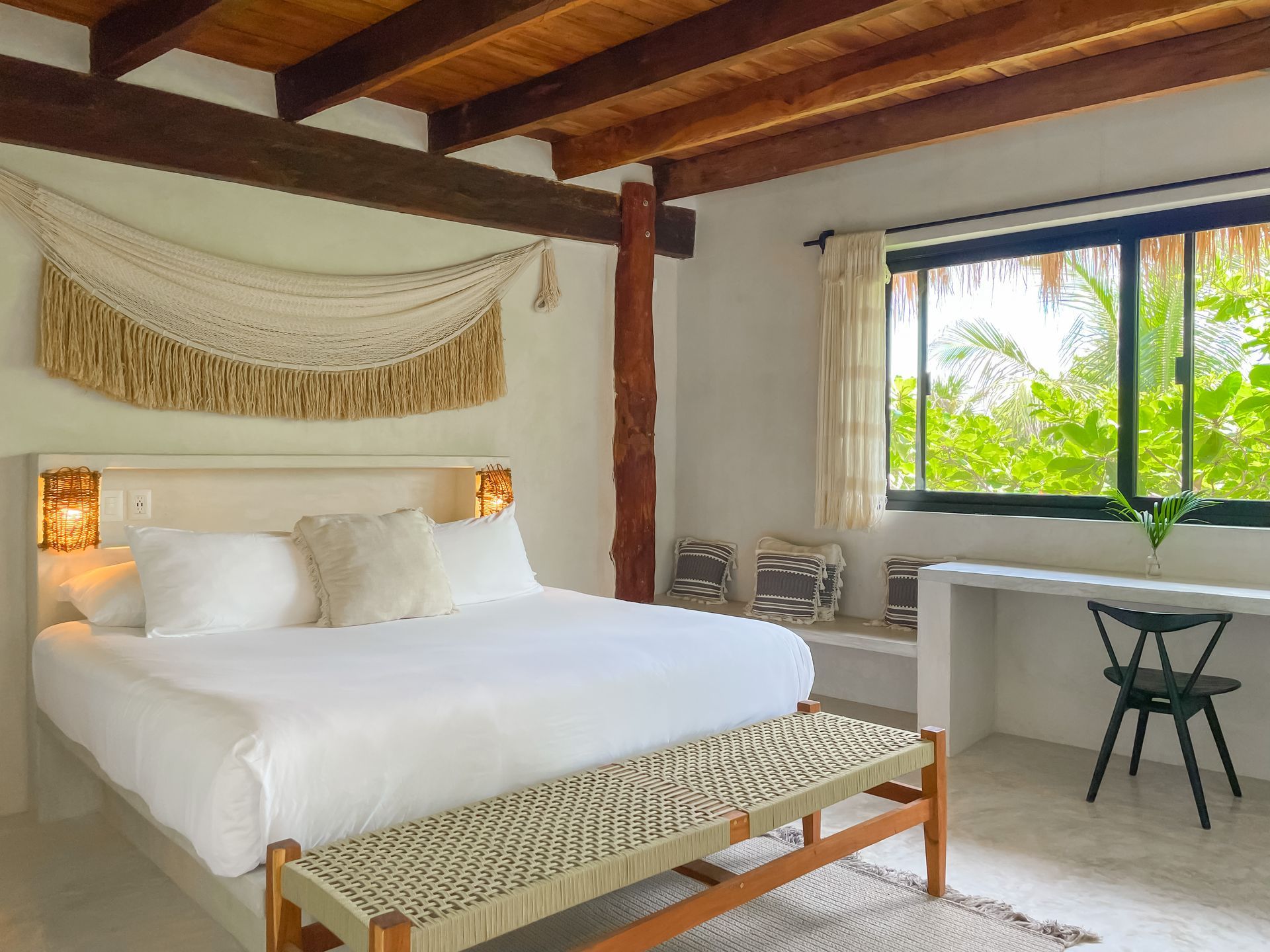 A bedroom with a king size bed and a bench.