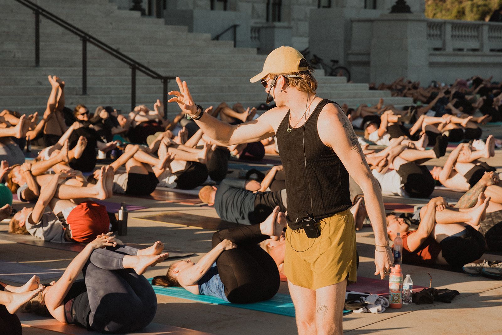 A man is standing in front of a group of people doing yoga.