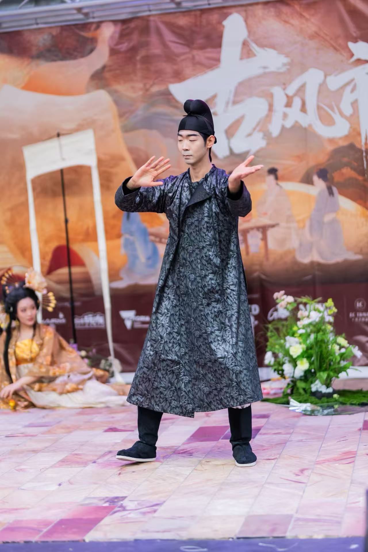 Man in traditional Chinese clothing performs on stage.