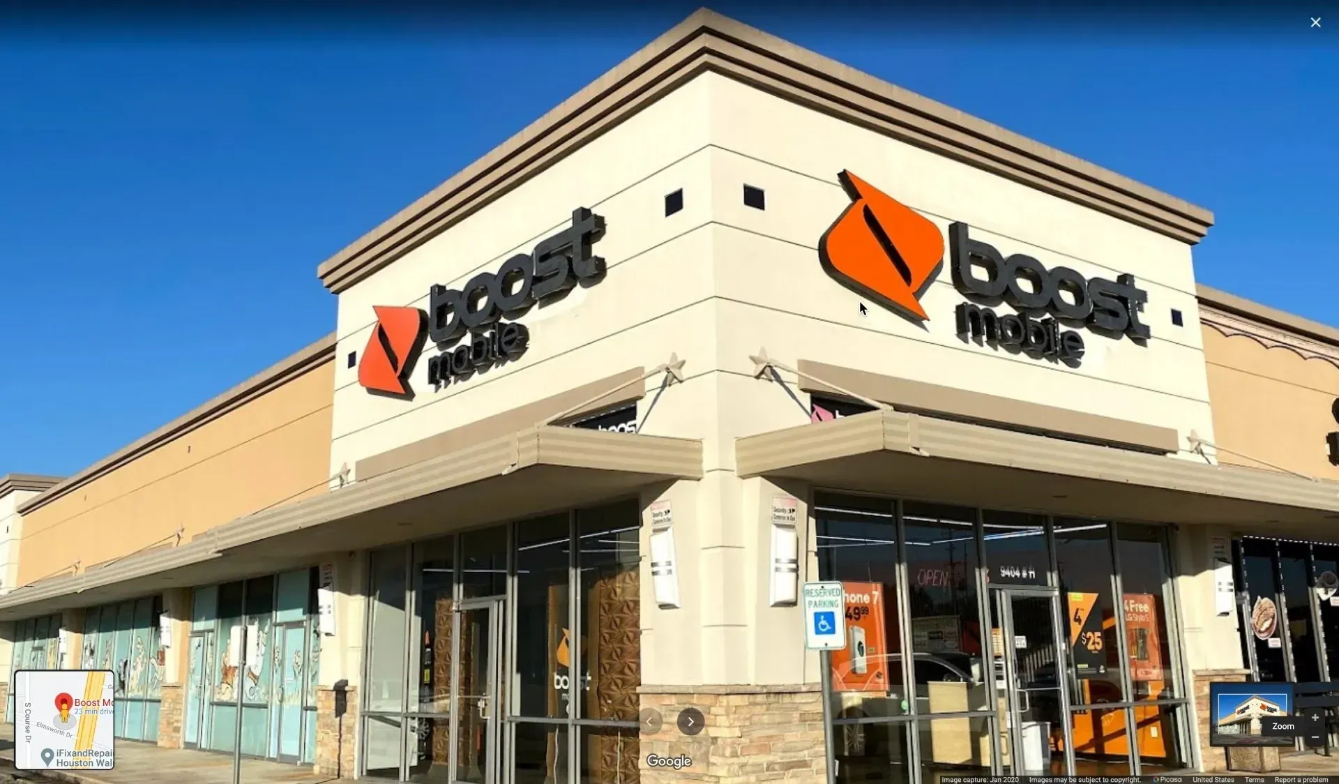 Boost Mobile store exterior with beige walls, dark signage, and a clear blue sky.