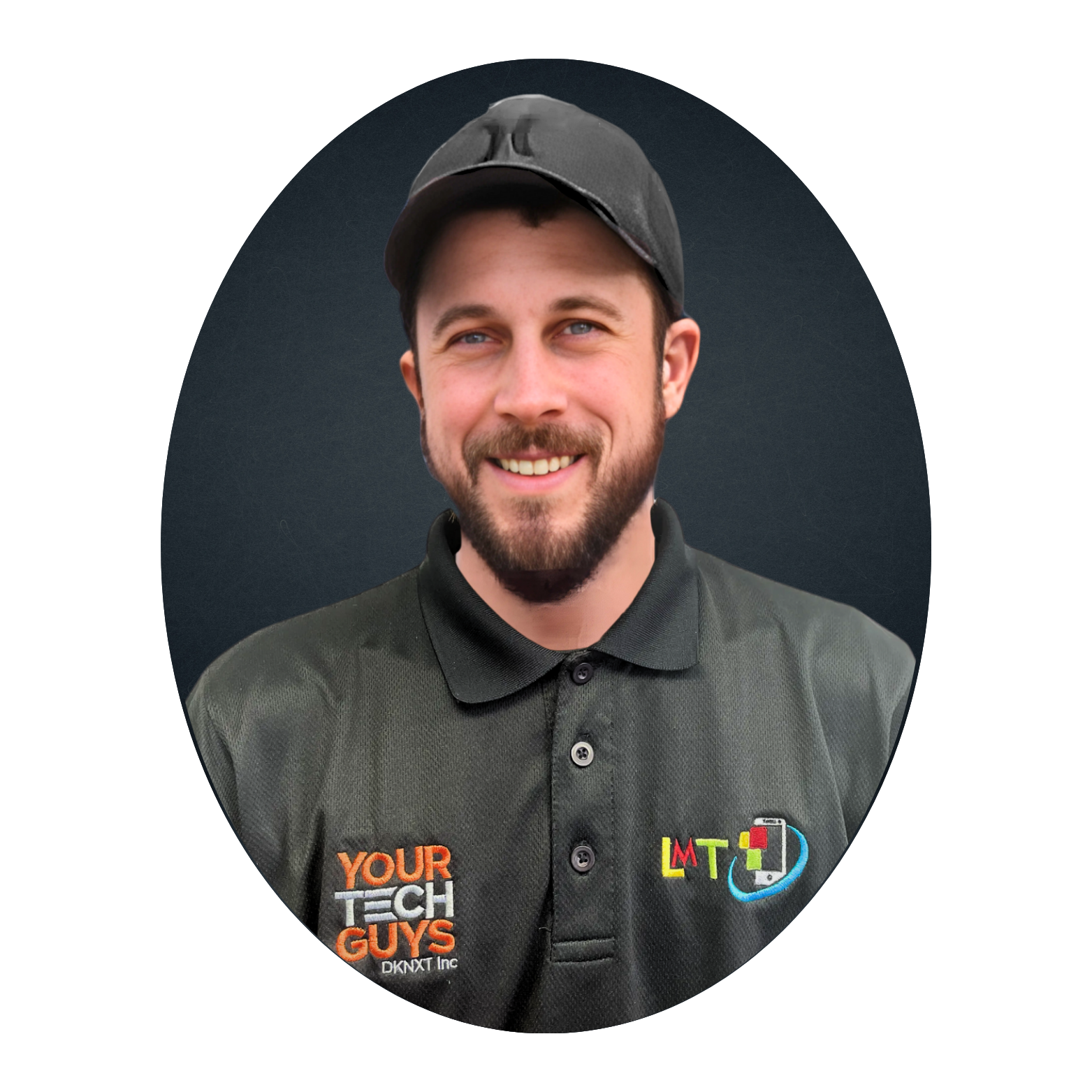 A smiling man with a beard, wearing a black cap and polo shirt with