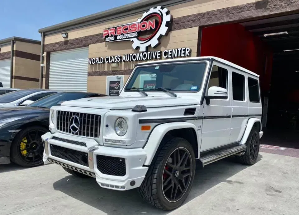 White Mercedes-Benz G-Wagon parked outside a 