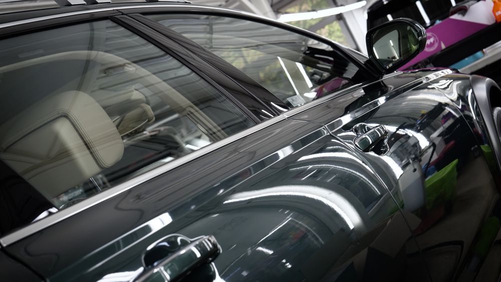 Un electricista con mono azul prueba una toma de corriente eléctrica con un multímetro, en el interior.