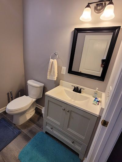 A bathroom with a sink , toilet and mirror.