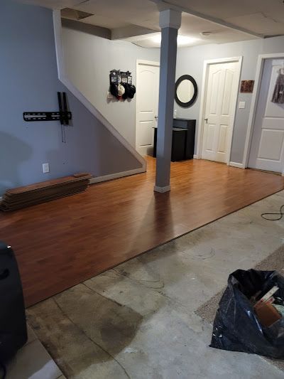 A living room with hardwood floors and a vacuum cleaner.