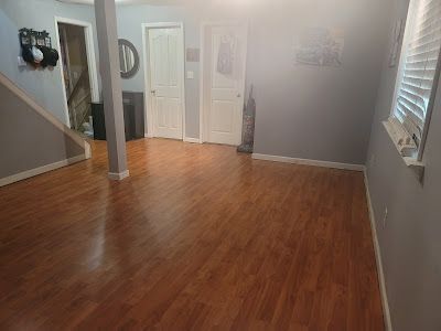 A living room with hardwood floors and a window.
