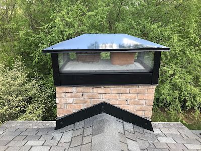 A brick chimney with a glass cover on top of it.