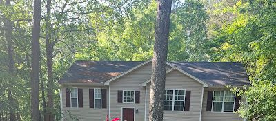 A house is surrounded by trees on a sunny day