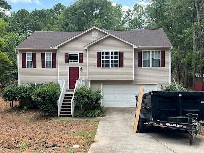 A large house with a dumpster in front of it.