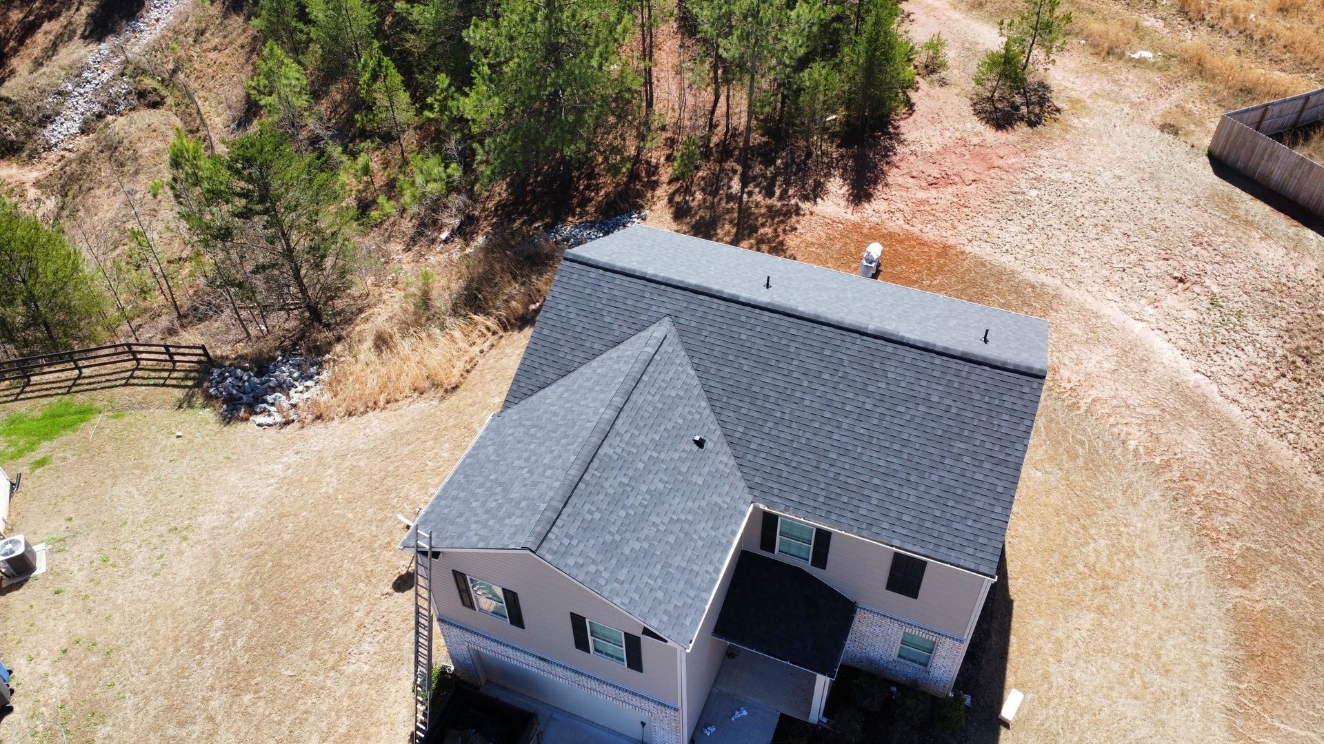 An aerial view of a house with a train in the background.