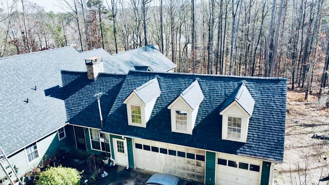 An aerial view of a large house with a car parked in front of it.