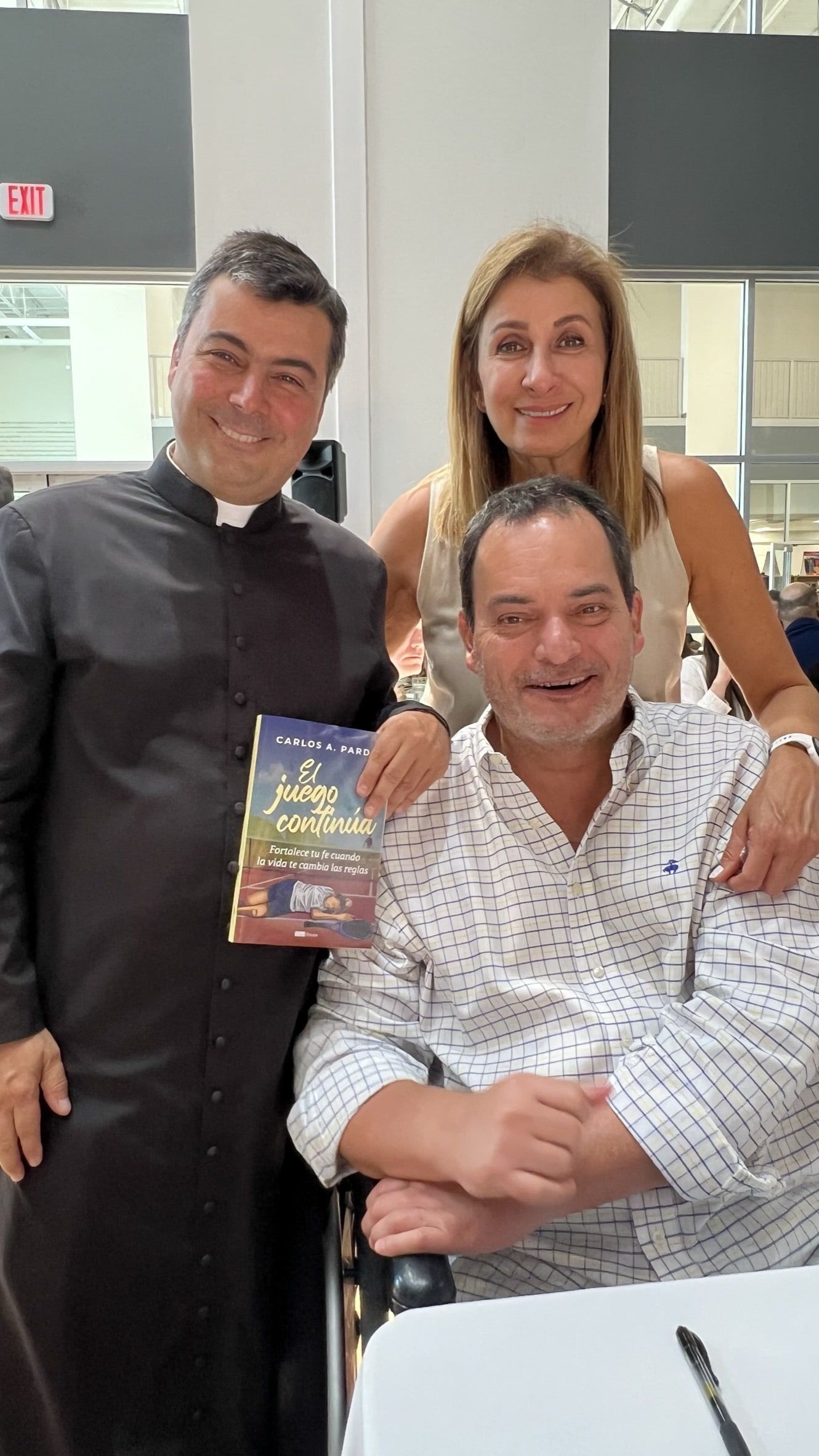 A man in a wheelchair is posing for a picture with two people.