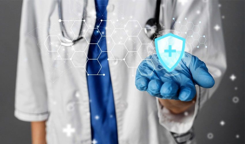 A doctor wearing blue gloves is holding a shield with a cross on it.