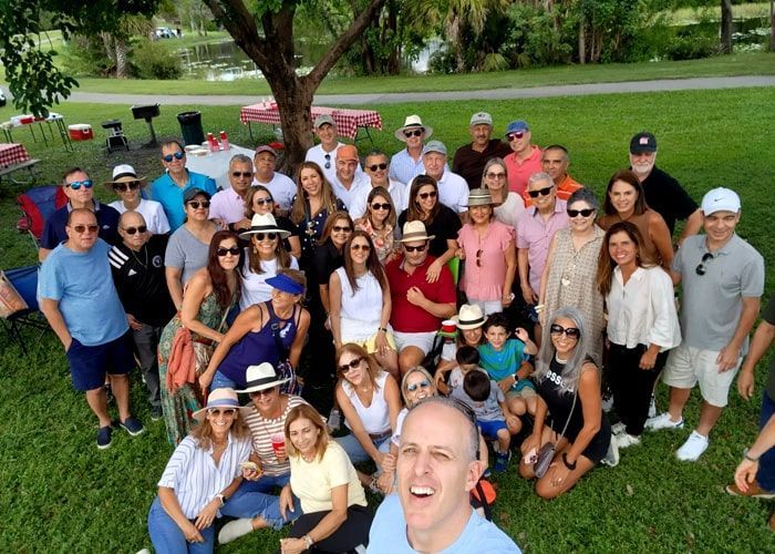 A large group of people are posing for a picture in a park.