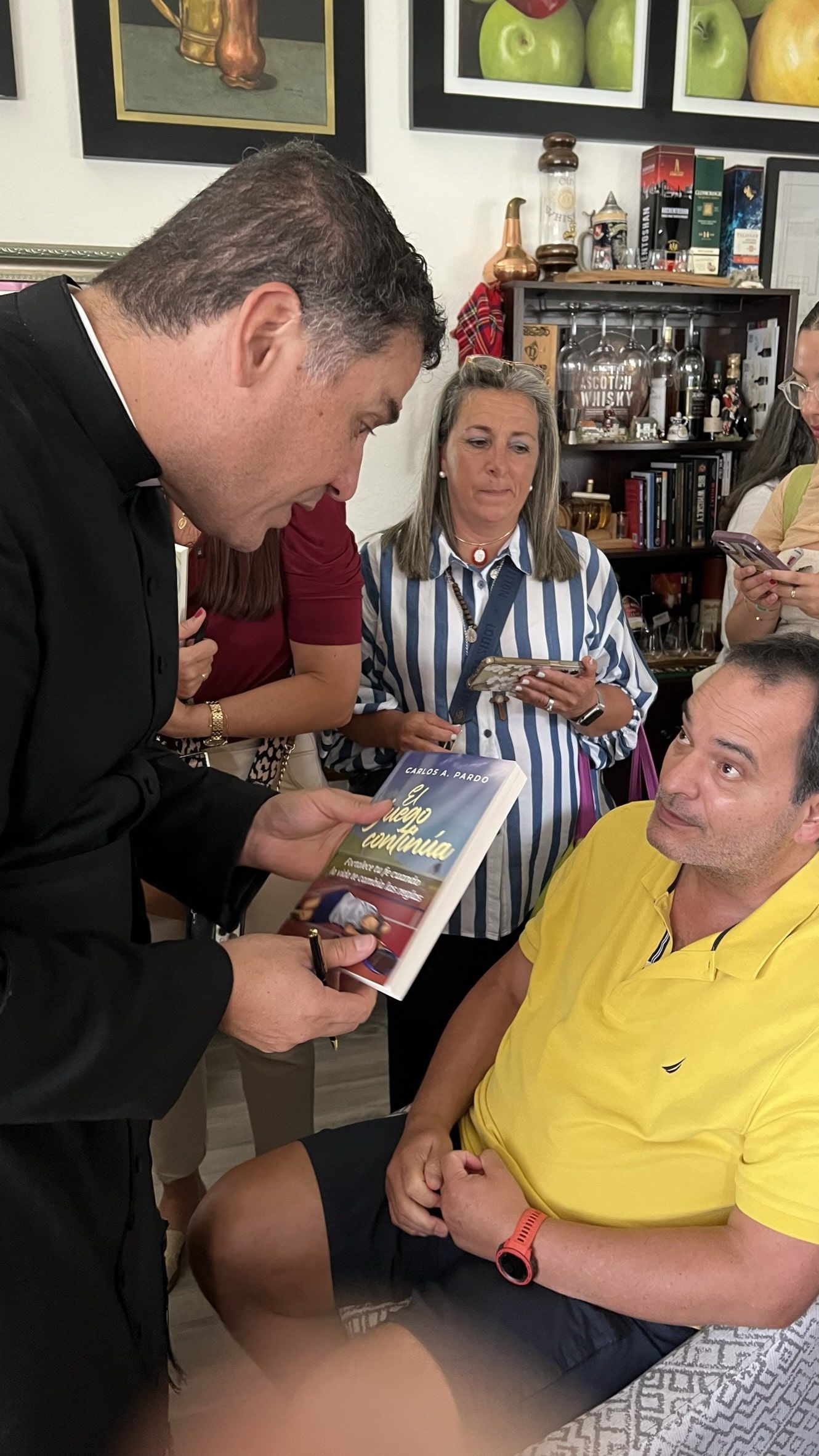 A guest requesting Carlos to sign his book