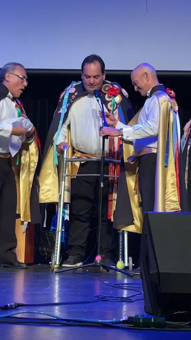 A group of men are standing on a stage in front of a microphone.