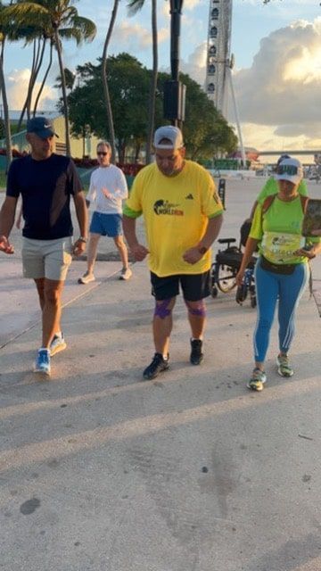 A man in a yellow shirt is walking with two other people