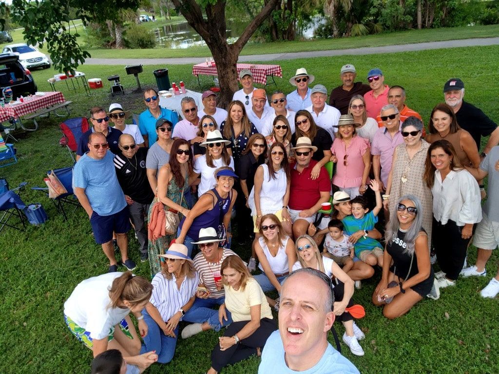 A large group of people are posing for a picture in a park.