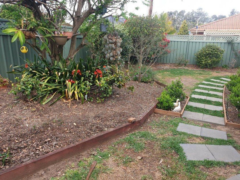 A Garden With a Fence and a Walkway Leading to It — Greener Gardens Gardening Service In Thrumster, NSW