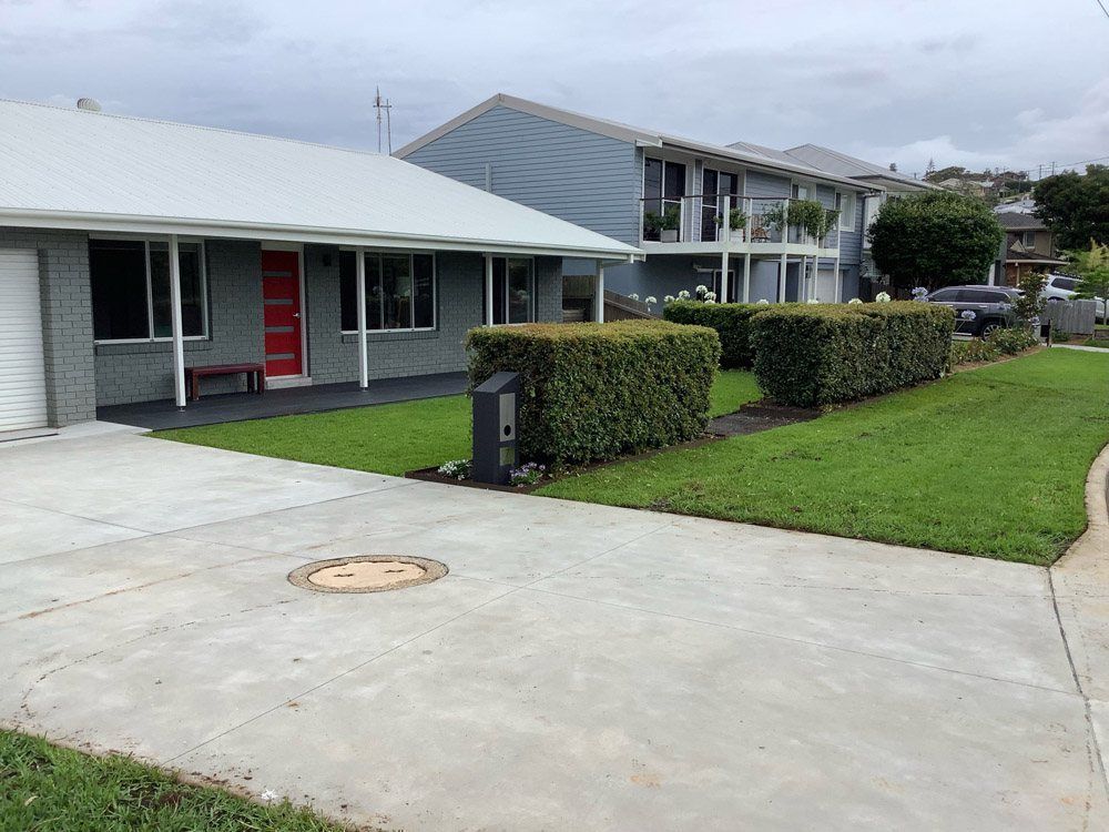 A House With a Concrete Driveway and a Lush Green Lawn in Front of It — Greener Gardens Gardening Service In Thrumster, NSW