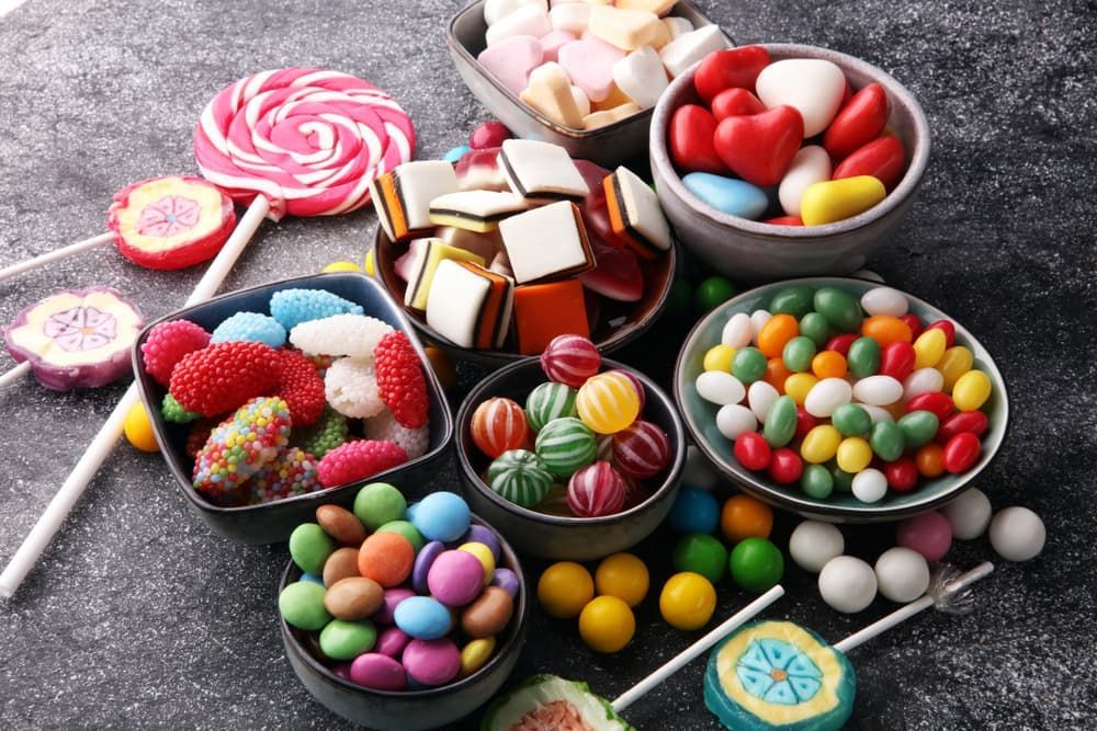 A Variety of Colourful Candies in Bowls on A Table — Mini Market Townsville Smoke Shop in Townsville City, QLD