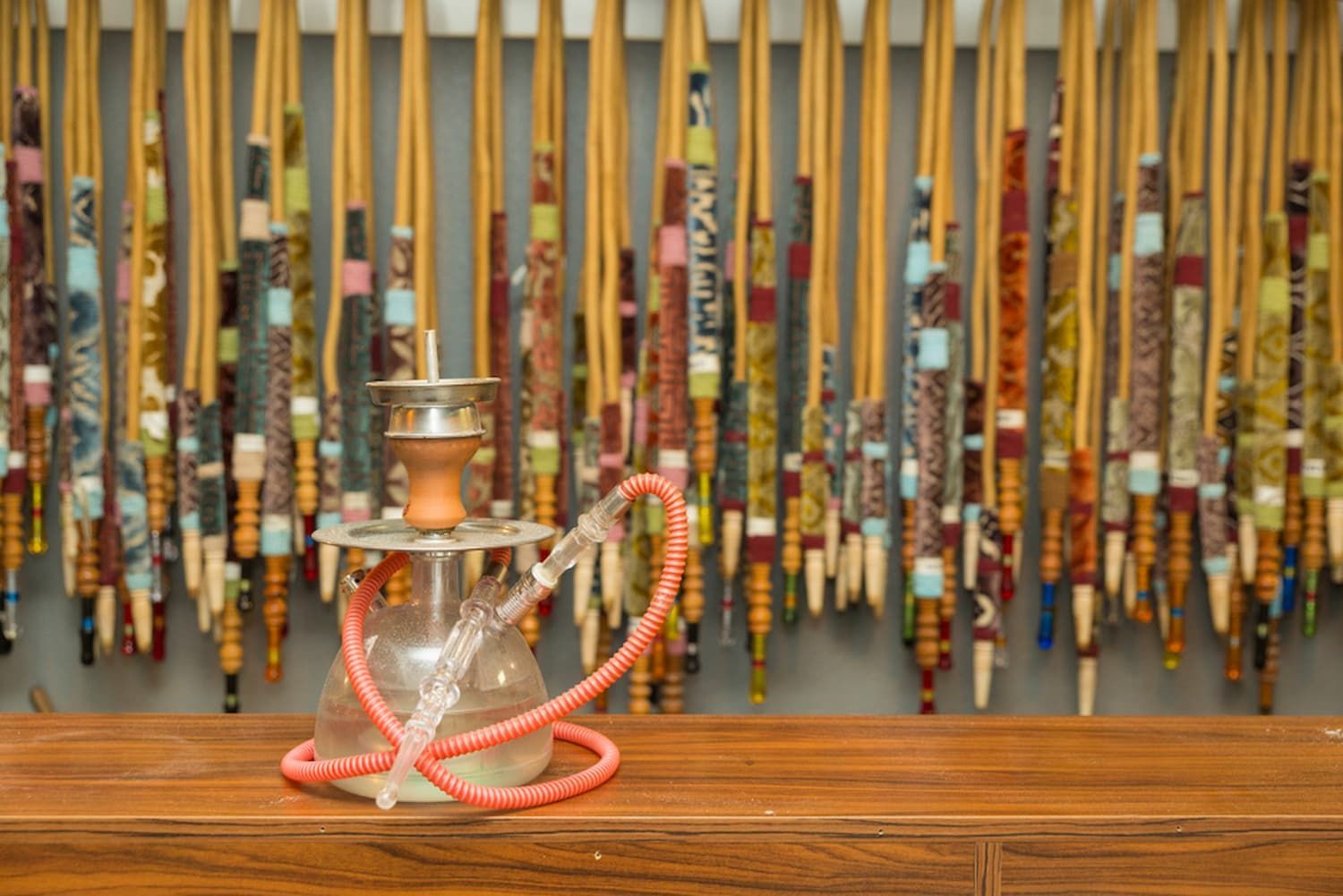 A Hookah Is Sitting on A Wooden Table in Front of A Wall of Hookahs — Mini Market Townsville Smoke Shop in Townsville City, QLD