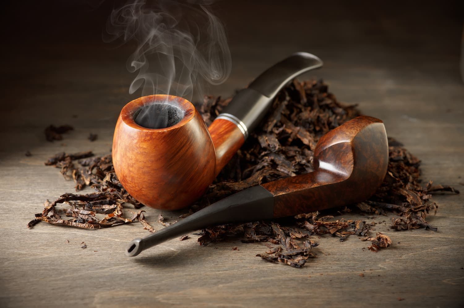 A Pipe Is Sitting on Top of A Pile of Tobacco Leaves on A Wooden Table — Mini Market Townsville Smoke Shop in Townsville City, QLD