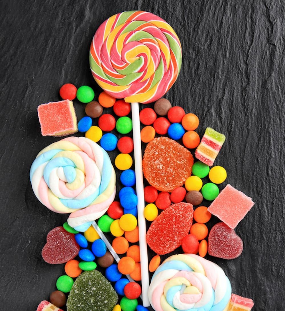 A Swirl Lollipop Is Sitting on Top of A Pile of Candy — Mini Market Townsville Smoke Shop in Townsville City, QLD